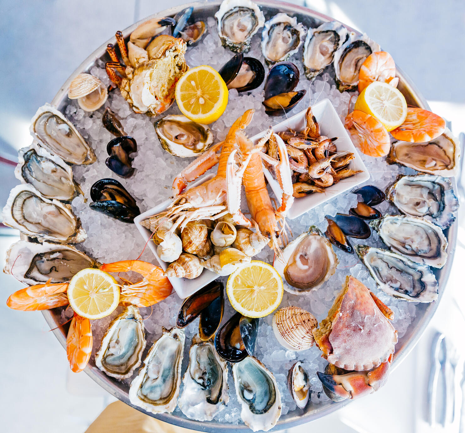 Directly above view of a round seafood plate with oysters, prawns, crabs and snails