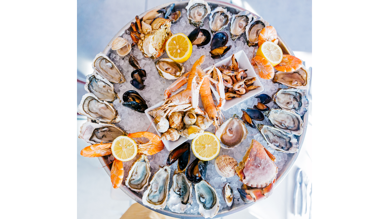Directly above view of a round seafood plate with oysters, prawns, crabs and snails