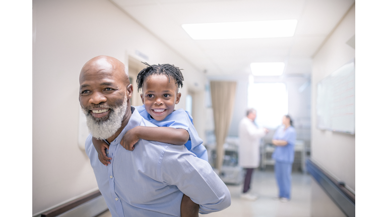 Smiling male doctor giving piggyback to patient