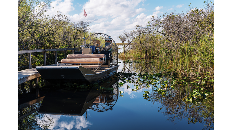 Airboat by pier in lake against sky at Everglades National Park