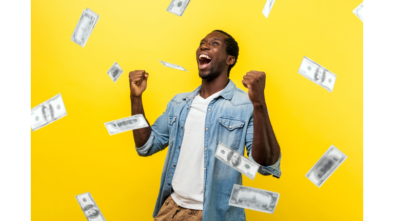 Money rain, winner and rich. happy young ecstatic motivated man standing with raised fists and shouting for joy, winner excited for success.
