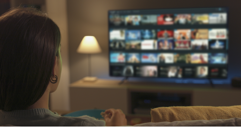 Young woman watching video on demand on her TV