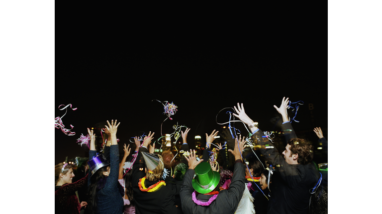 People celebrating on rooftop at New Years Eve party, rear view
