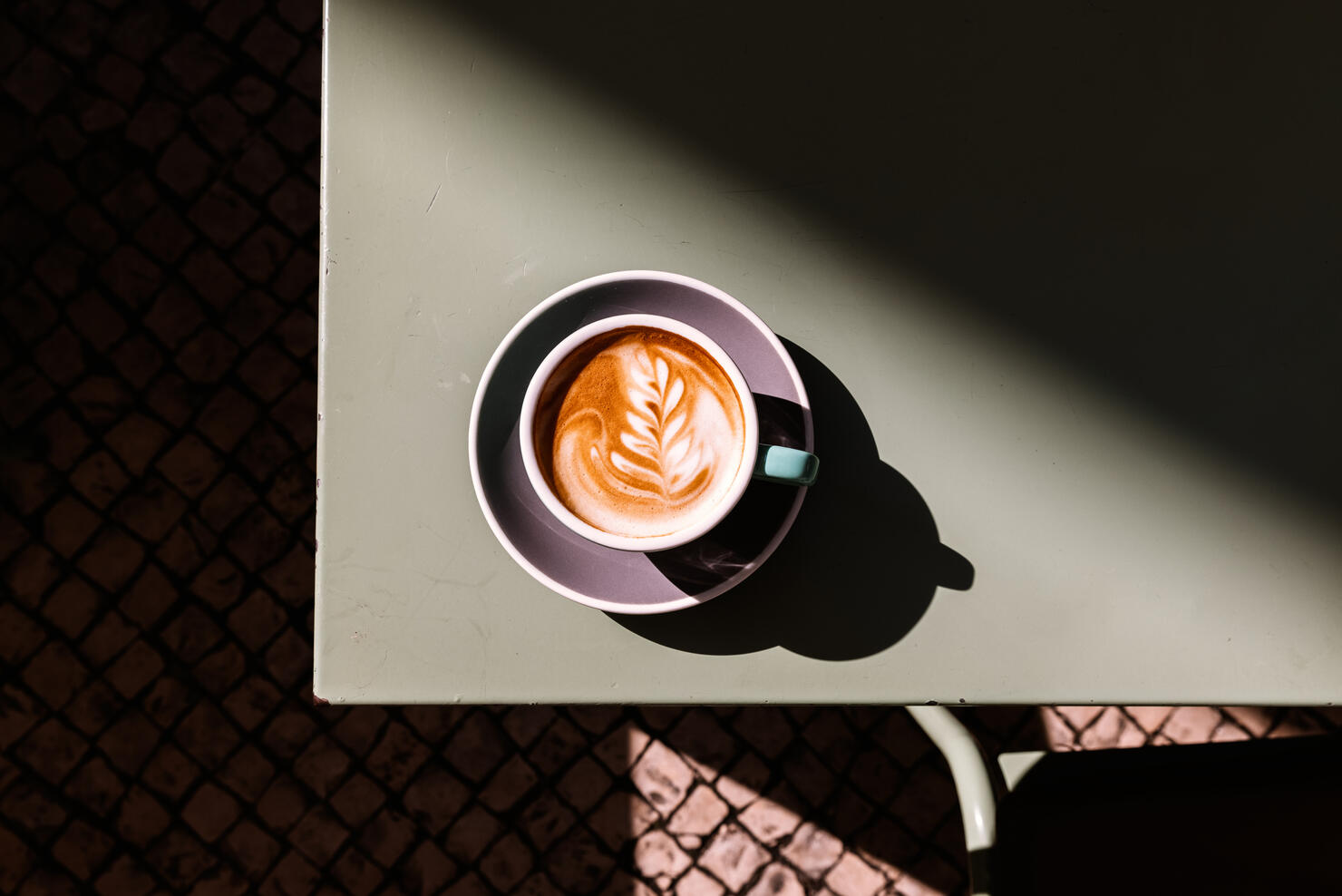 Cup of cappuccino with latte art on the table, directly above view