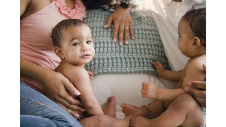 Parents sitting on sofa with twin baby boys