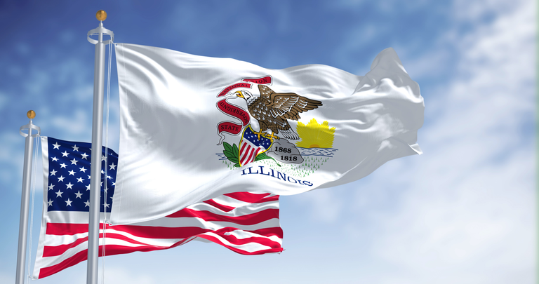 The Illinois state flag waving along with the national flag of the United States of America