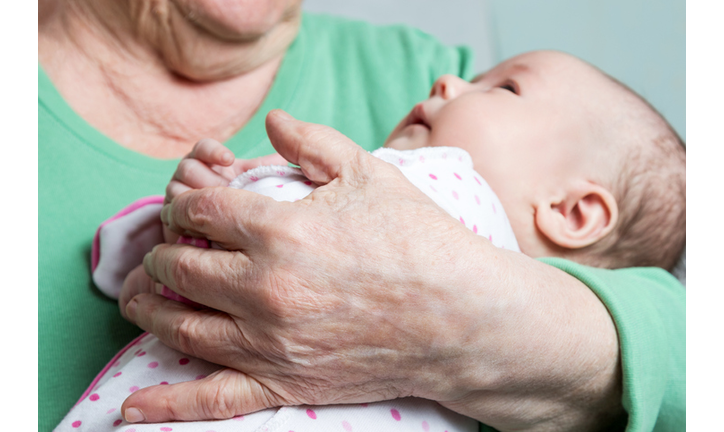 Baby on hands at old woman