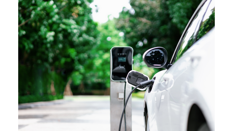 Focus closeup EV car and charger with blur background for progressive concept