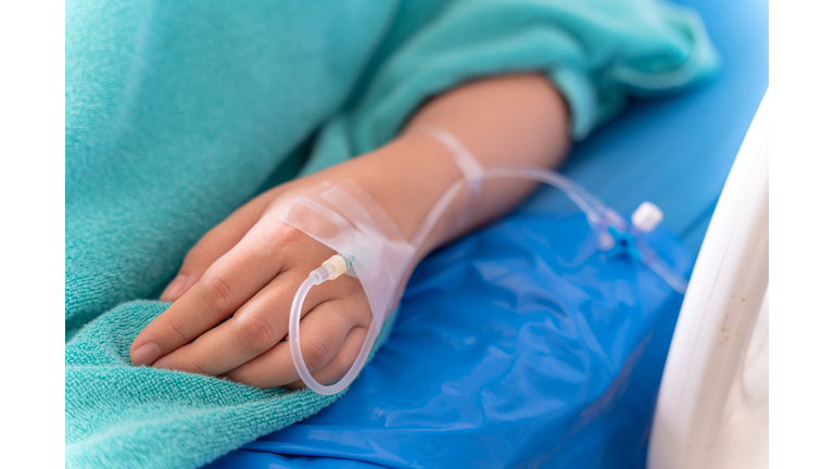 hand of the patient is on drip receiving a saline solution on bed VIP room at hospital. Medical Concept.