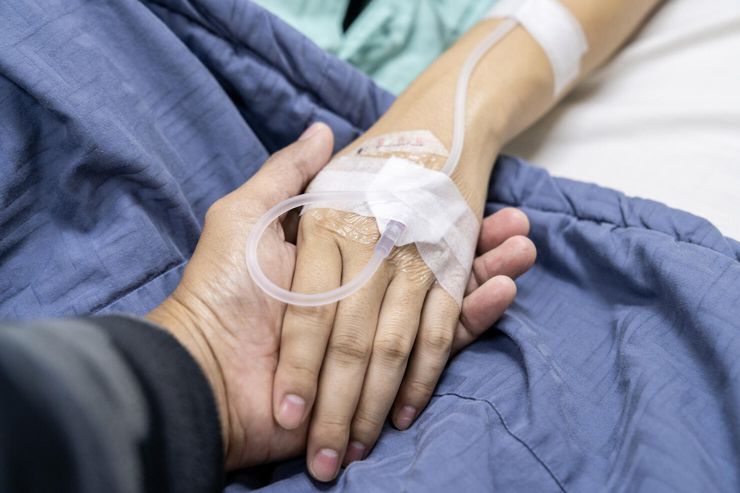 A patient's hand on a recovery bed