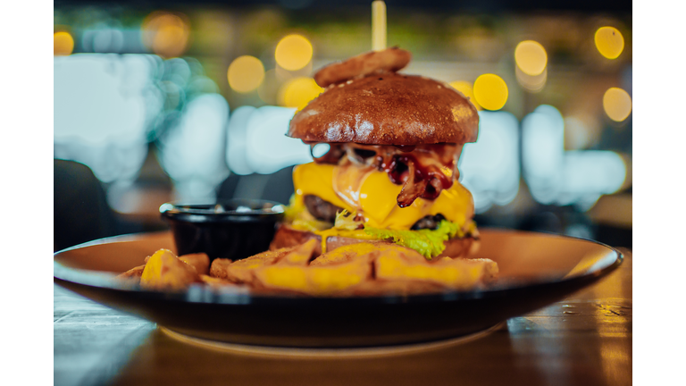 Burger in bun with cheese and vegetable garnish