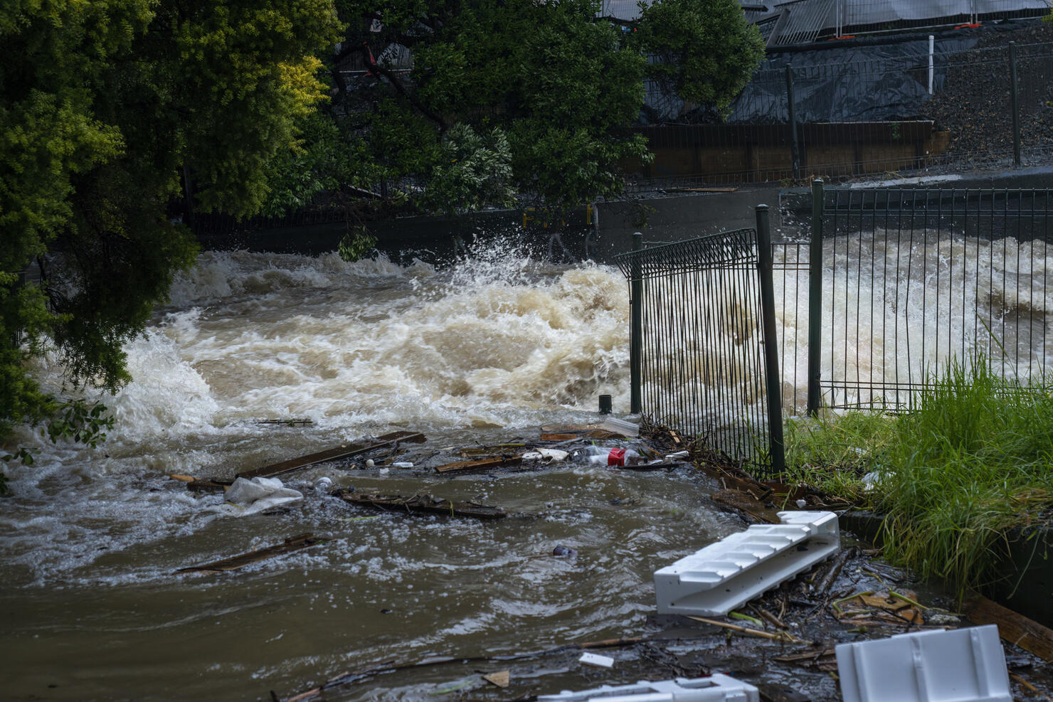 Storm water gushing down the Wairua stream, carrying rubbish along the way. Auckland after the heavy rain.