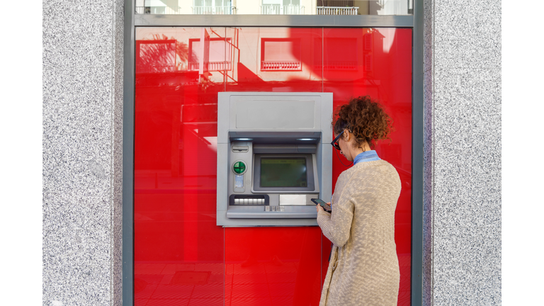 Latin woman using ATM