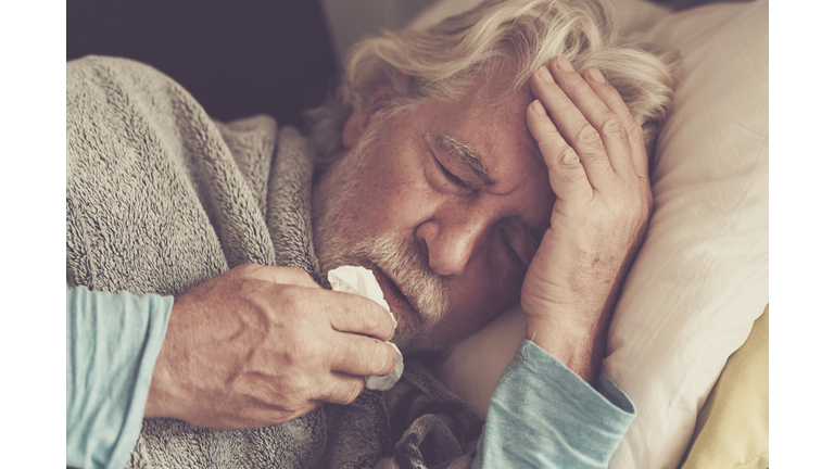 Old people senior man with winter seasonal illness fever cold problems drinking a pharmacy medicine or hot tea to go healthy - concept of mature retired with disease