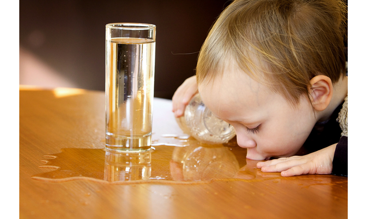 Boy sipping water from table