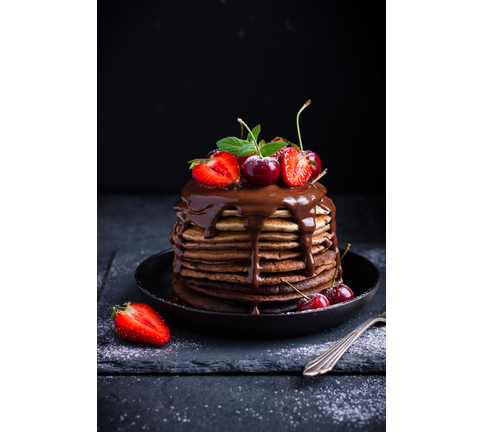 Ombre chocolate pancakes with fresh berries and chocolate sauce