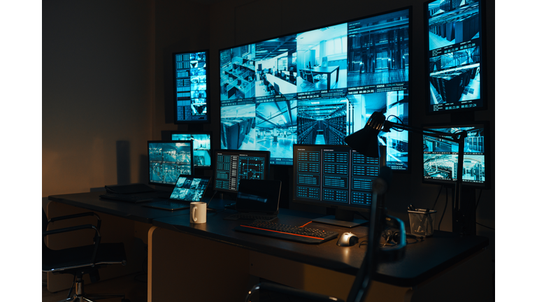 A security workplace with a modern high-tech control panel in the form of large monitors that display real-time information from external video surveillance cameras for 24 hours.