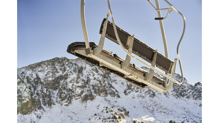 low angle view of an empty chairlift with no people moving on the cable, with the sky in the background