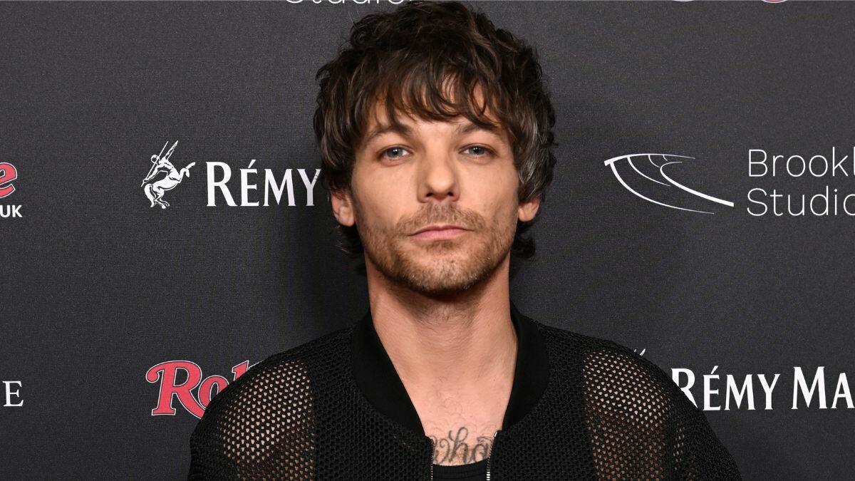 Louis Tomlinson Signs Marriage Certificate During Fan Meet & Greet iHeart