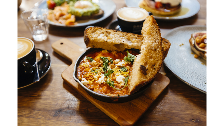 Close up of shakshuka served in cooking pan on the table in cafe