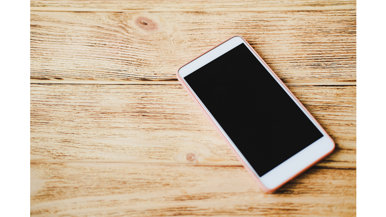 Smartphone on wooden surface.