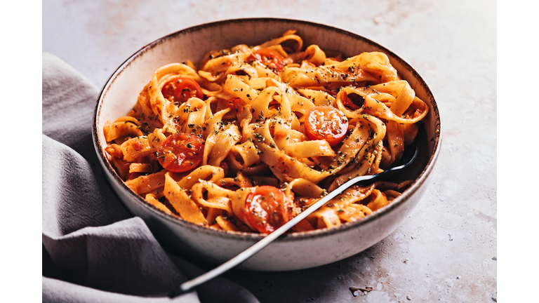 Tagliatelle with tomato sauce on stone background
