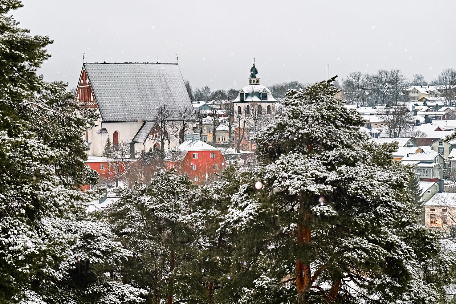 Old historic Porvoo, Finland with wooden houses and medieval stone and brick Porvoo Cathedral under white snow in winter