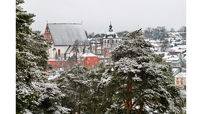 Old historic Porvoo, Finland with wooden houses and medieval stone and brick Porvoo Cathedral under white snow in winter