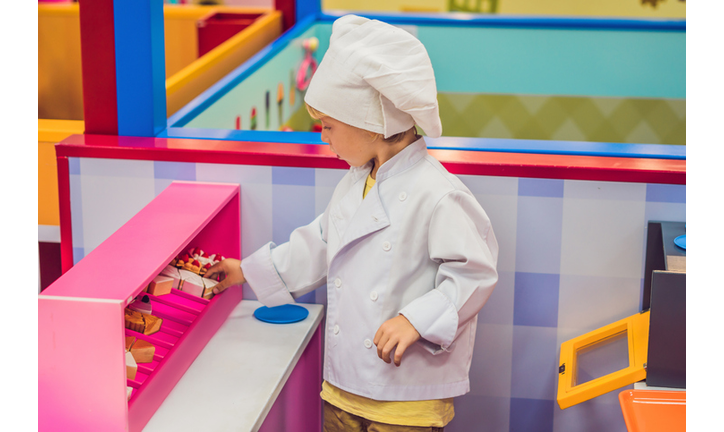 The boy plays the game as if he were a cook or a baker in a children's kitchen