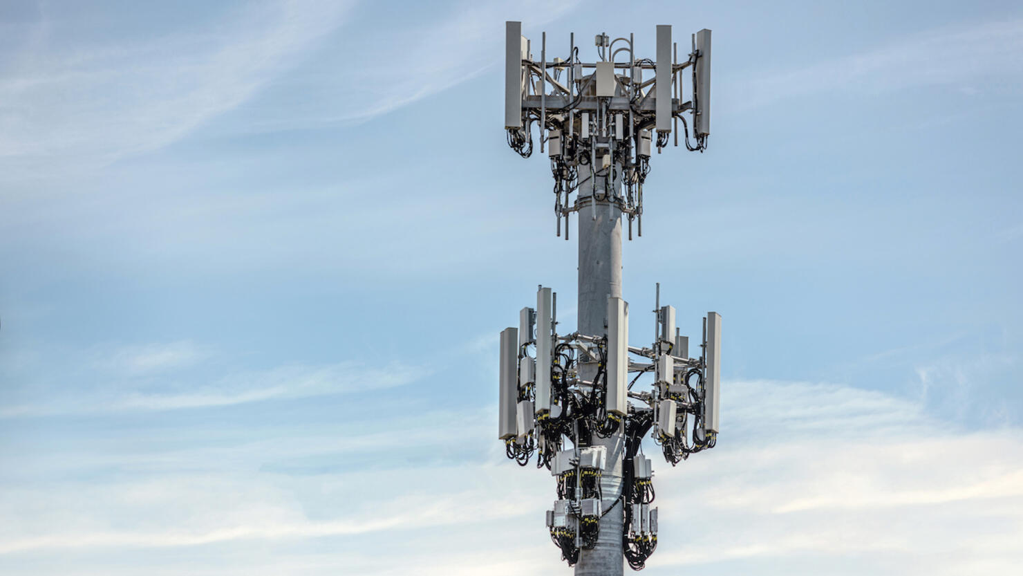 Communications cell tower mobile phone data blue sky clouds