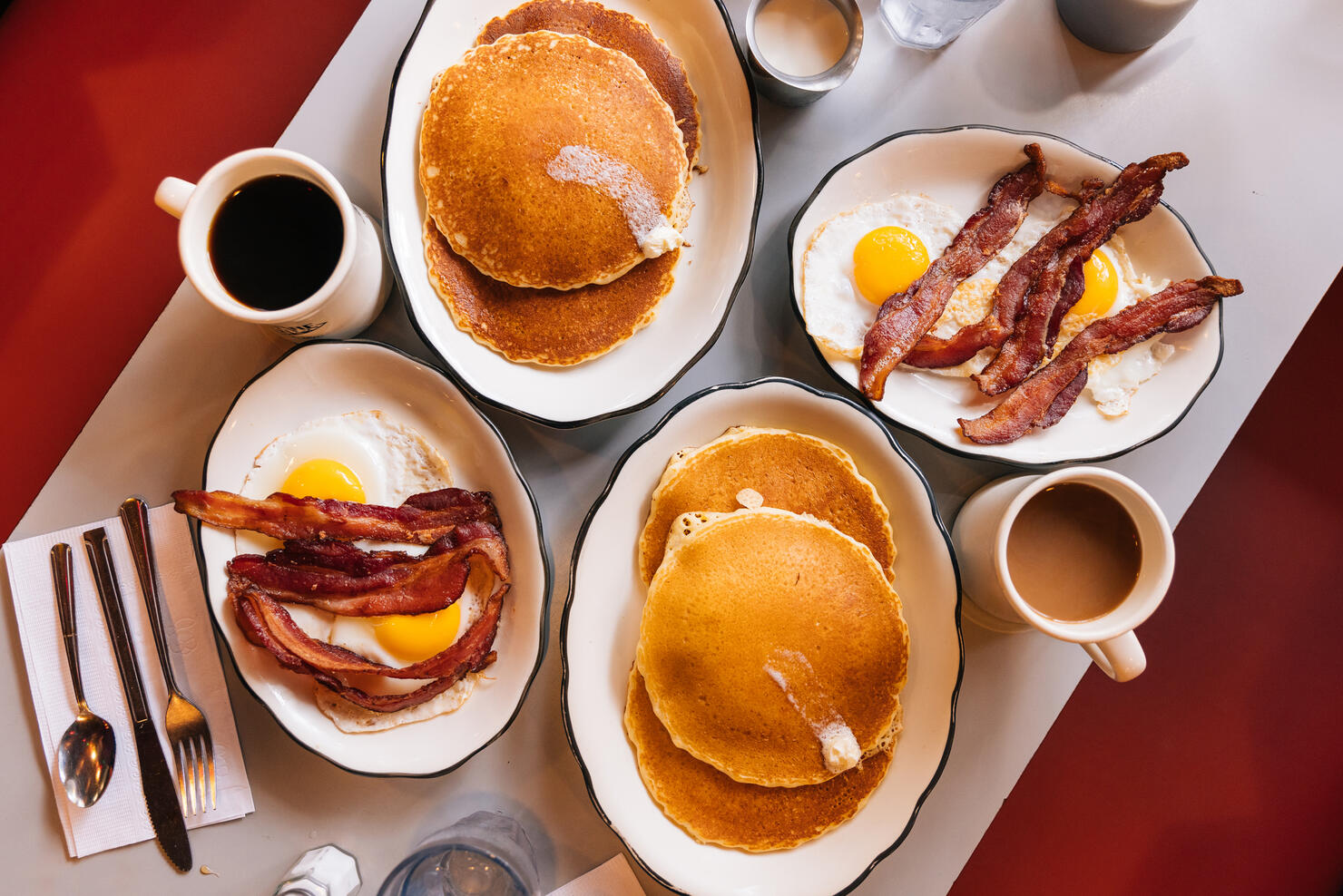 American breakfast at the diner with fried eggs, bacon and pancakes