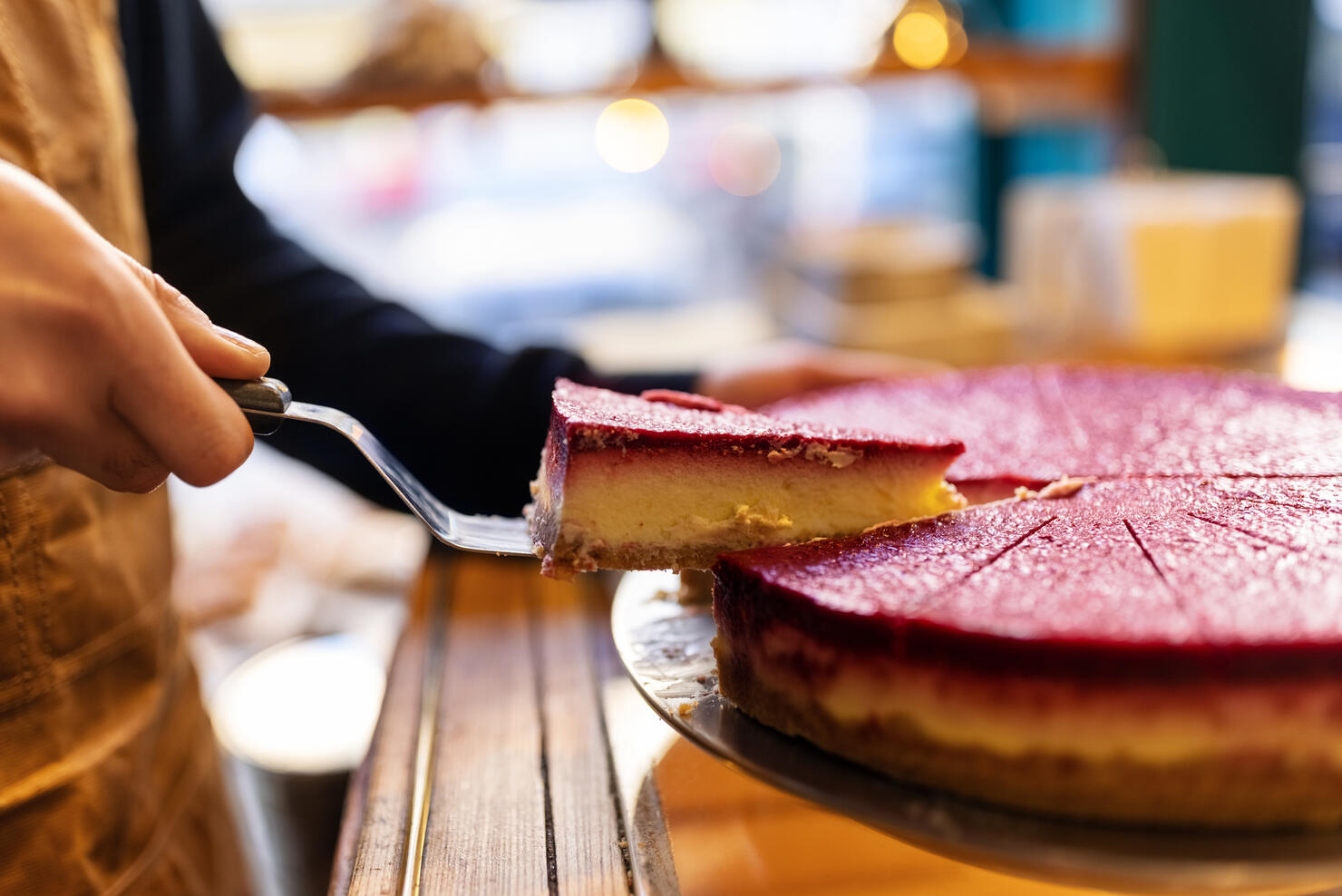 Waiter serving slice of cake at cafe