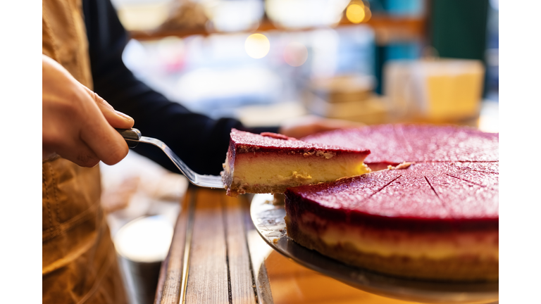 Waiter serving slice of cake at cafe