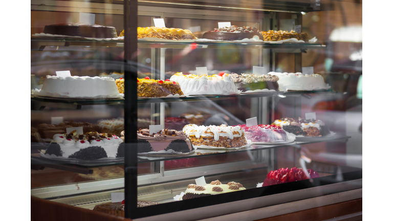 Appetizing cakes in the window of a pastry shop. Tasty sweets on the baking store shelves