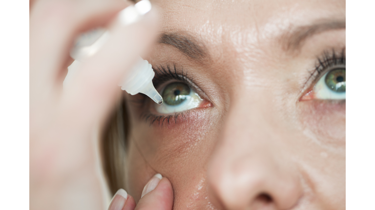 Woman usind eyedropper...applying eye drops