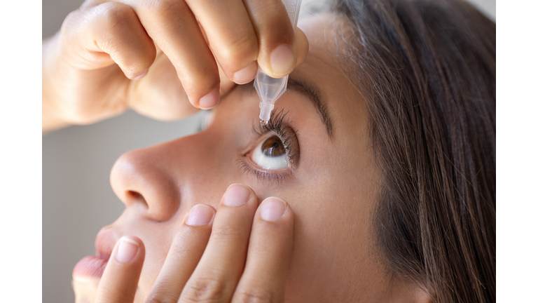 Ophthalmology. A woman instills medicine into her eye.
