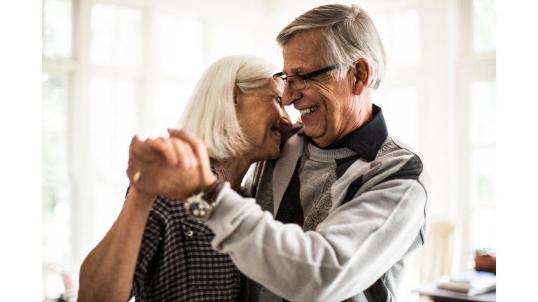 Senior couple dancing in living room