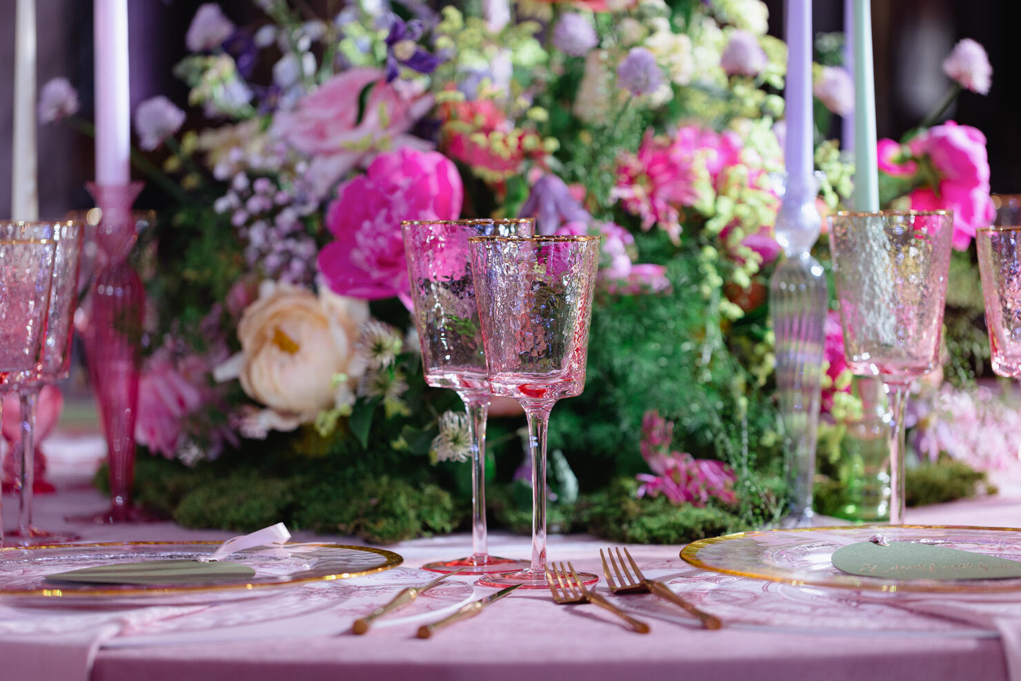 Golden cutlery and pink wineglasses on the decorated table