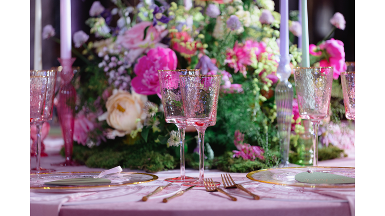 Golden cutlery and pink wineglasses on the decorated table