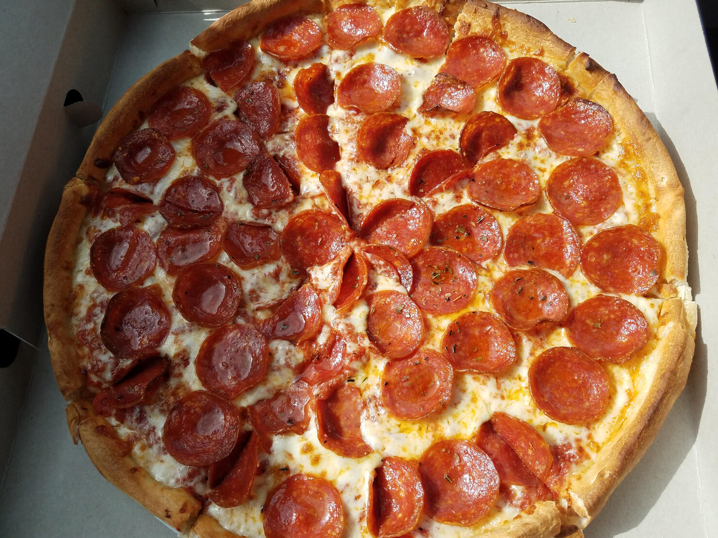 pepperoni pizza in cardboard box with grease