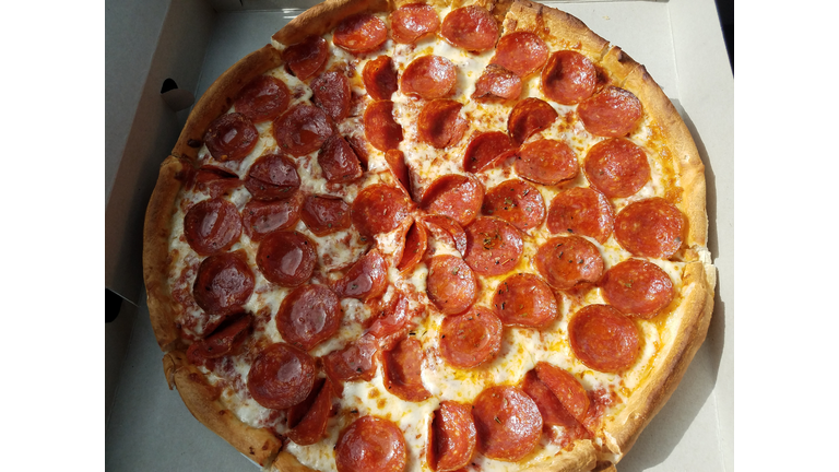 pepperoni pizza in cardboard box with grease