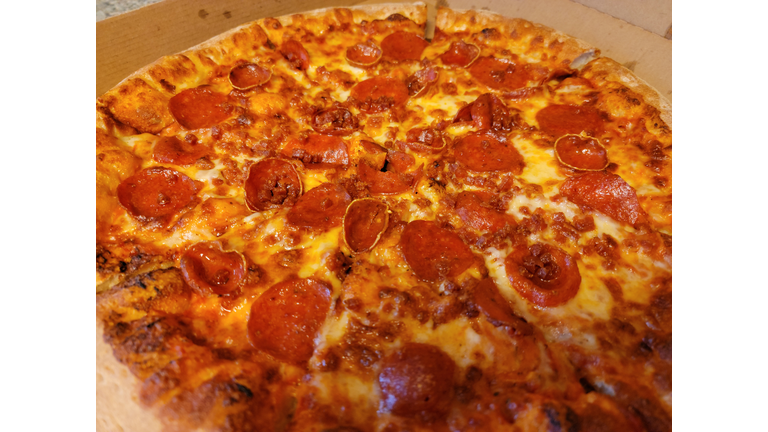 greasy pepperoni meat sliced pizza in cardboard box