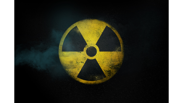 Nuclear energy radioactive round yellow symbol on asphalt texture