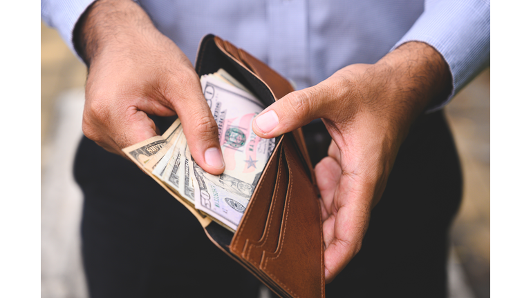 Close up Business man counting the money spread of cash in wallet.