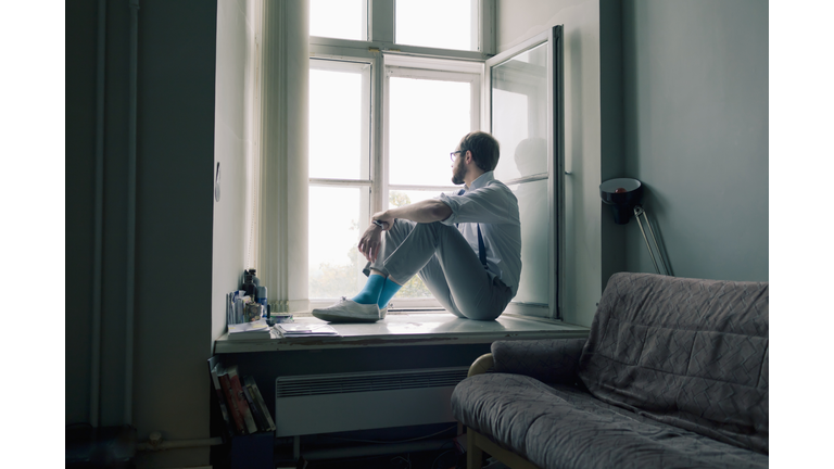 Man sitting on window sill