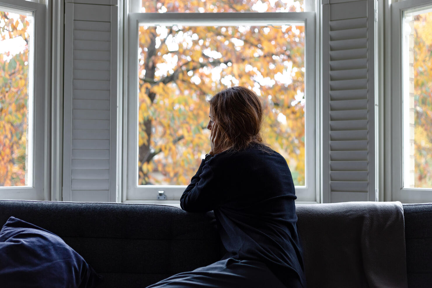 A woman looking through the window... Social distancing.