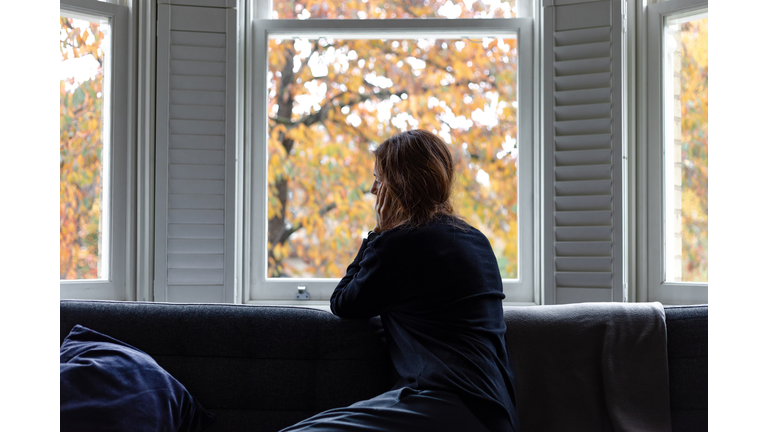 A woman looking through the window... Social distancing.