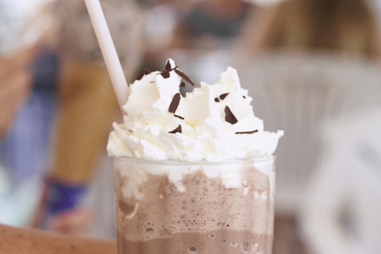 close-up of a woman's lips drinking from a frappuccino in a restaurant, side view