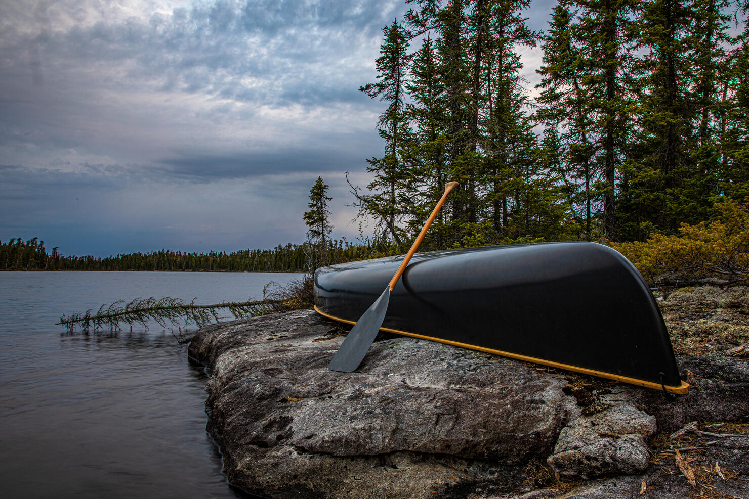 Canoe on shore with storm approaching.