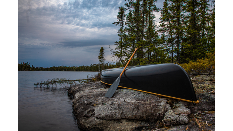Canoe on shore with storm approaching.